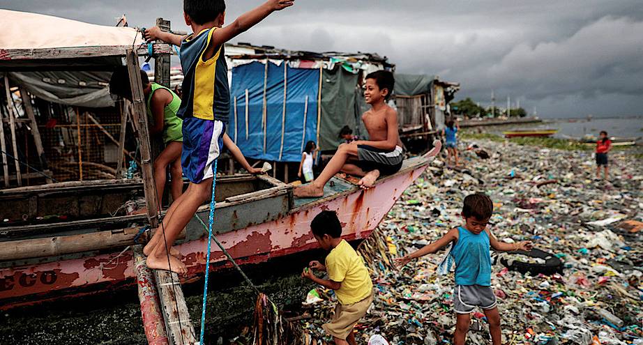 Фото дня: дети играют на пляже, заваленном мусором