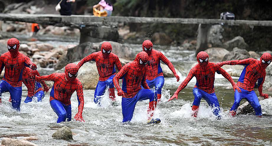 Фото дня: группа людей, одетых как человек-паук, бежит по реке в Китае