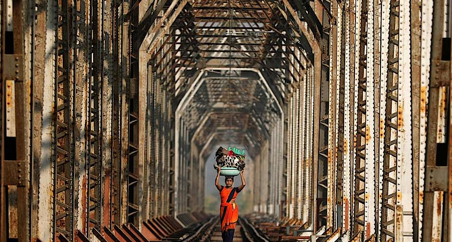 Фото дня: женщина идет по железнодорожным путям недалеко от Мумбаи